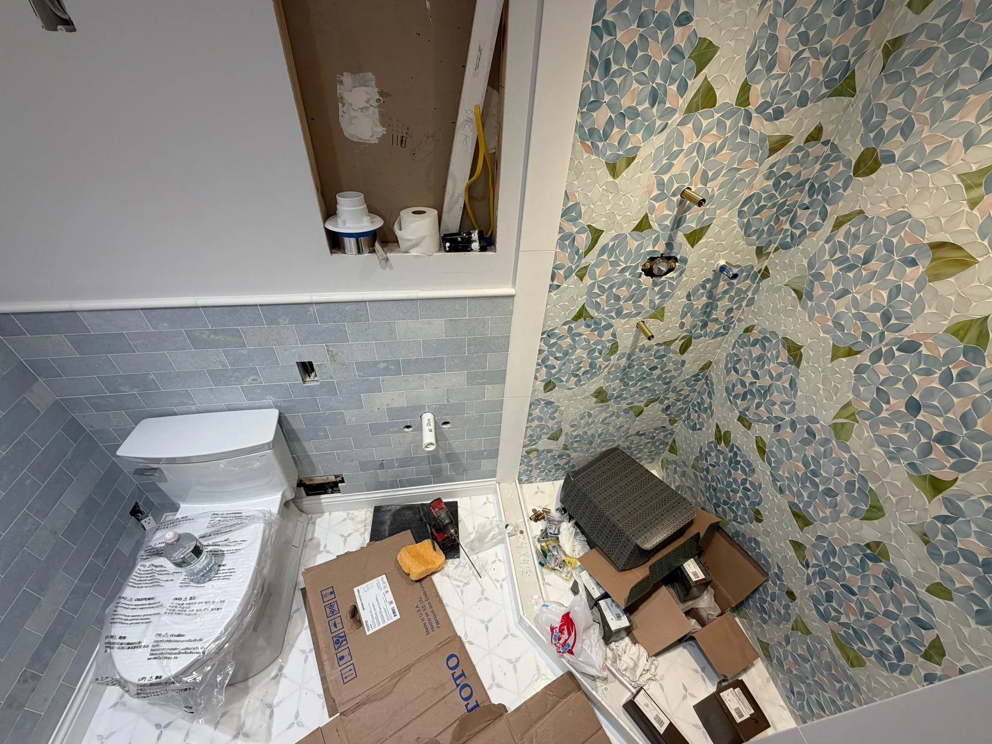 Bathroom remodel in progress with a new Toto toilet and a tiled shower