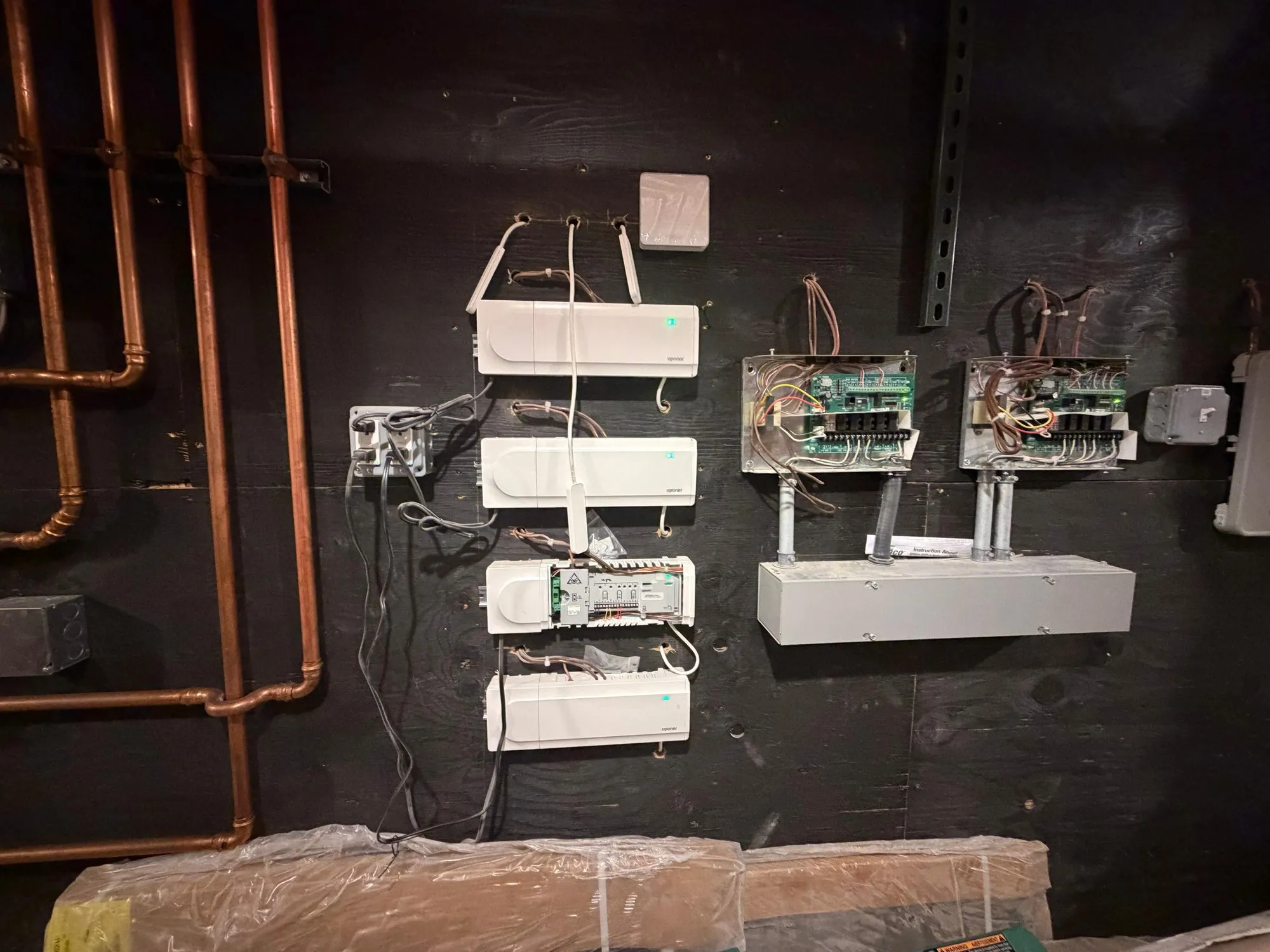 Heating zone control panels and relays wired on a mechanical room wall