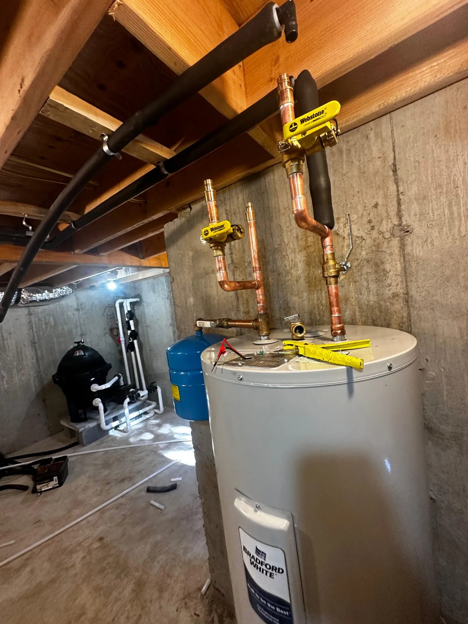 Bradford White tank water heater installed with new copper piping and shutoff valves in a crawlspace